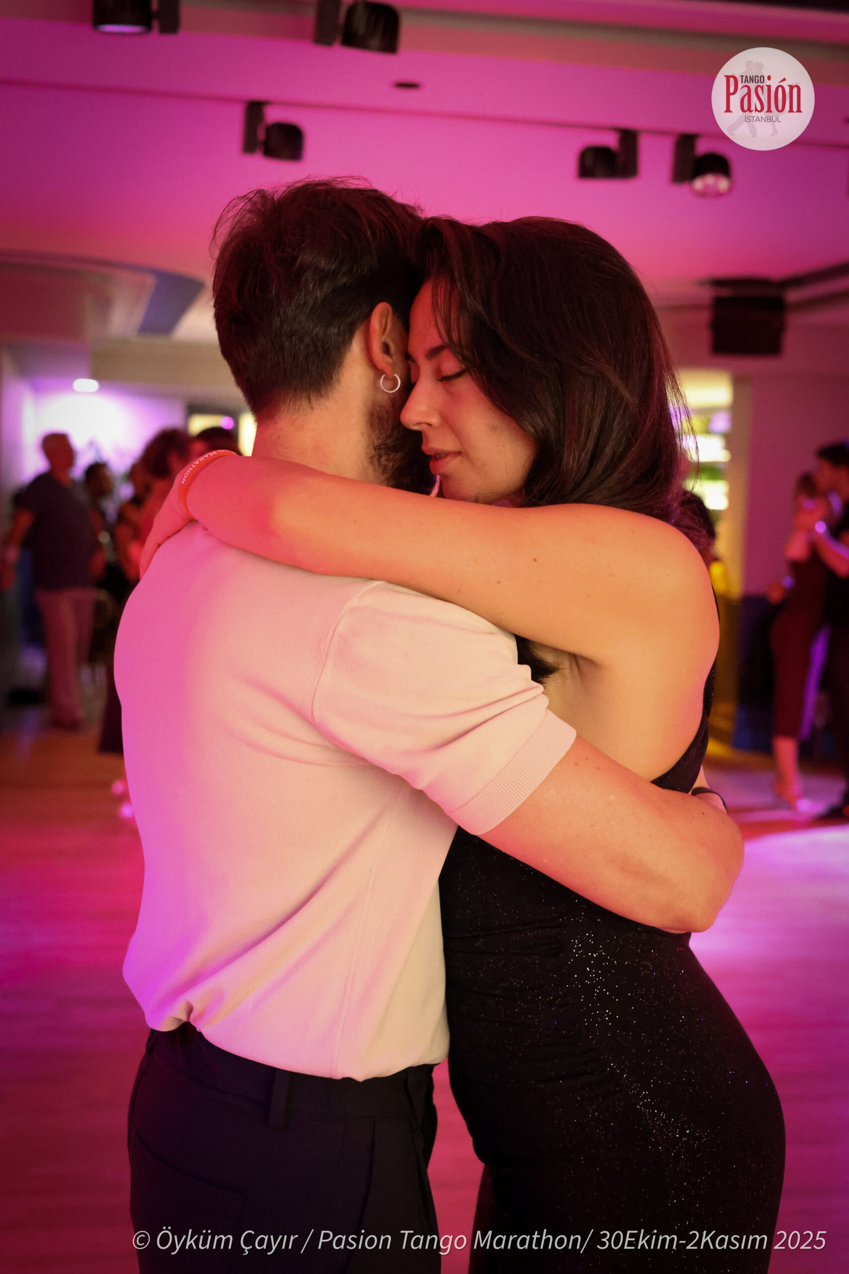 A couple dancing cheek to cheek during a milonga